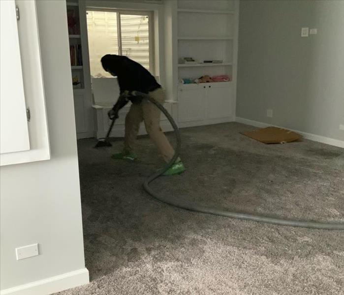 Employee removing water from carpet