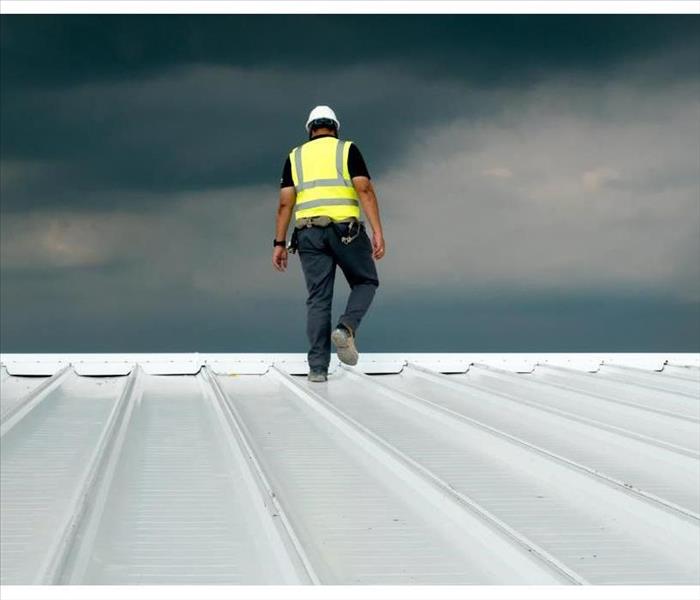 Man walking on a roof wearing a helmet. Concept of roof inspection 