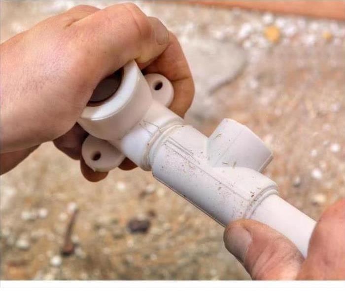 Hand holding a polybutylene pipe.